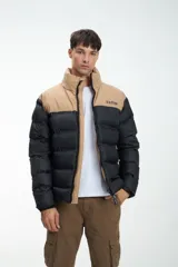 Campera puffer negra y beige con cierre frontal y cuello alto. Estampado con la marca "Unfrm" en el pecho.