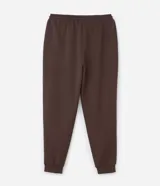 Pantalón jogger de pijama color negro, confeccionado en tejido de modal con mezcla de poliéster y elastano. Presenta cintura elástica con cordón de ajuste, bolsillos laterales y puños ajustados en el ruedo.