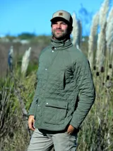 Campera capitoneada de color verde oliva, con cuello de pana marrón, cierre frontal con botones a presión y bolsillos delanteros con solapa.