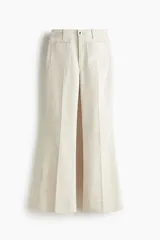 Pantalón de tiro alto confeccionado en pana de algodón, con diseño acampanado, bolsillos de parche frontales y pliegues marcados en el frente y la espalda.