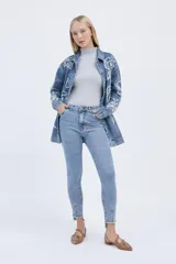 Jean skinny de tiro alto color celeste, con zócalo irregular y pinza de entalle en botamangas.