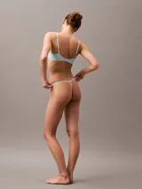 Colaless celeste con encaje elástico transparente y tiras delgadas.