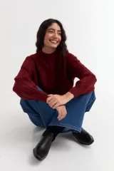 Sweater de punto color bordó con diseño de ochos, cuello redondo y mangas largas con puños acanalados.