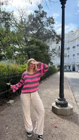 Blusa de punto con diseño de rayas horizontales en color fucsia y gris, de corte holgado, cuello redondo y mangas largas acampanadas.