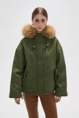 Campera parka de algodón color verde militar, con capucha forrada en piel sintética, cierre frontal oculto, bolsillos laterales y cordones ajustables en la capucha.