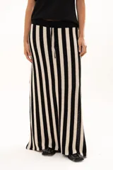 Pollera larga tejida a rayas verticales en color rojo y blanco, con pretina elástica y tajos laterales profundos que aportan movimiento.