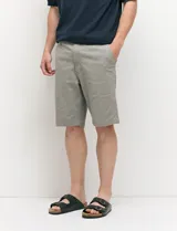 Bermuda chino de corte recto, color verde militar, confeccionada en algodón con elastano. Cuenta con bolsillos laterales de estilo italiano y bolsillos traseros con botón.