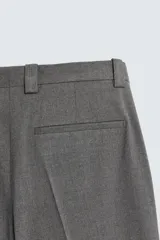 Pantalón de corte wide fit confeccionado en tejido fluido con viscosa. Presenta bolsillos delanteros, bolsillos traseros de vivo, cierre frontal con cremallera y botón, y trabillas para cinturón.
