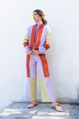 Pantalón de corte recto y tiro alto con diseño de bloques de color en tonos lila, terracota y amarillo pálido. Confeccionado en una mezcla de poliéster y spandex, ofrece un ajuste cómodo y versátil.