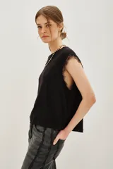 Musculosa blanca de lino con cuello redondo y detalle de encaje en las mangas.