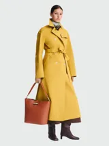 Bolso tipo hobo de cuero color terracota, con cierre metálico dorado y correa de hombro ajustable.