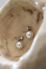 Par de aros plateados con perlas blancas y strass.