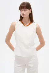 Musculosa blanca sin mangas de viscosa, con ajuste al cuerpo, cuello a la base y detalles de vivos.