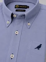 Camisa de algodón twill color blanco de corte clásico, con cuello button-down, bolsillo en el pecho con detalle bordado y botones en tono contrastante con costuras en cruz.