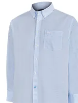 Camisa de manga larga RKF con diseño a cuadros en tonos celeste y blanco. Presenta cuello abotonado, bolsillo en el pecho con logo bordado y tecnología wrinkle-free.