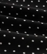 Blusa de crepé con estampado de lunares, diseño cruzado con escote en V, mangas largas con puños elásticos y lazo lateral ajustable. Incluye forro interno.