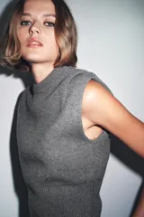 Chaleco de punto confeccionado en mezcla de lana color gris. Presenta cuello redondo, manga sisa con detalle de pliegues en los hombros y un bajo ancho en punto elástico que entalla la cintura.