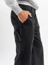 Pantalón estilo carpintero de corte regular y tiro medio, confeccionado en algodón resistente. Presenta bolsillos laterales, traseros y utilitarios, con cierre de botón y cremallera y terminación de pierna recta.