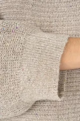 Suéter de punto color gris claro con cuello barco, mangas tipo murciélago y diseño de corte largo. Presenta un tejido con sutiles motas de colores que aportan un efecto brillante.