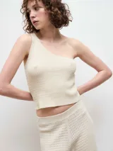 Top de punto con diseño de un solo hombro, confeccionado en tejido texturizado de color beige.