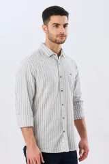 Camisa de manga larga de lino y algodón, con diseño de rayas verticales en tonos celestes y blancos. Presenta cuello camisero, cierre frontal con botones y pequeño bordado al tono en el pecho.