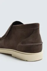 Bota casual de piel con acabado serraje color beige, con detalle de bordón en el empeine, horma redonda y suela a contraste.