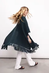 Ruana tejida en lana merino color ladrillo, con textura de punto grueso.