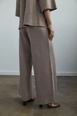 Pantalón de piqué color gris topo, de tiro medio con cintura elástica interior y diseño de pierna ancha.