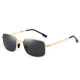Lentes de sol con marco metálico dorado de forma rectangular y cristales oscuros. Cuentan con patillas finas y terminales de acetato negro.