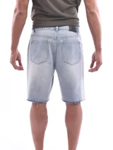 Bermuda de jean corte recto en color celeste claro, con diseño desgastado que incluye roturas y desflecados en los muslos y ruedos.