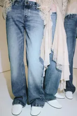 Jeans de tiro bajo color azul claro, con corte bootcut, cinco bolsillos y cierre frontal de cremallera y botón.
