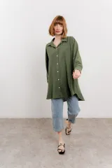 Camisa verde militar con estampado de lunares blancos, de corte oversize, con cuello camisero, cierre frontal con botones y bolsillo en el pecho.