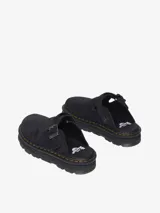 Mule Dr. Martens Zebzag de gamuza negra, con suela híbrida de EVA y PVC, correa ajustable con hebilla plateada y las icónicas costuras amarillas de la marca.