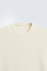 Camiseta negra de punto perlado, corte regular fit, cuello redondo, manga corta y rib en los acabados.