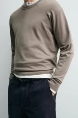 Sweater de punto relaxed fit confeccionado en hilatura con viscosa de tacto suave, color marrón, con cuello redondo y manga larga. Cuenta con acabados en rib.
