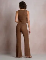 Pantalón de tiro alto con tejido calado y textura labrada, de corte recto con apertura acampanada hacia el ruedo. Cuenta con cintura elastizada y cordón de ajuste con terminaciones de caracoles decorativos.