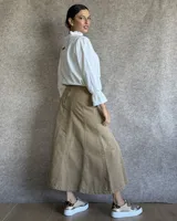 Pollera larga de denim color celeste claro, con corte en A y talle alto con elástico en la cintura.