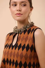 Vestido corto sin mangas con estampado de rombos en azul, rojo y amarillo. Tiene escote con forma de gota y terminación en picos.