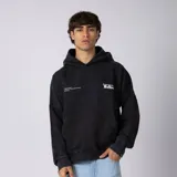 Buzo canguro negro de algodón rústico con efecto lavado washed, capucha, bolsillo canguro y estampa frontal en blanco. Cuenta con aberturas para el pulgar en los puños.