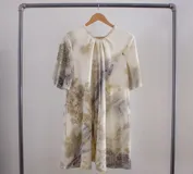 Vestido acampanado color amarillo con estampado de hojas en la parte superior, bolsillos laterales y teñido natural.