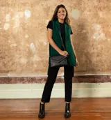 Botín de cuero vacuno color negro, con diseño combinado de cuero liso en la parte delantera y cuero con textura de reptil en el talón. Cuenta con un taco cuadrado de madera, cierre metálico en la parte posterior y suela de goma.