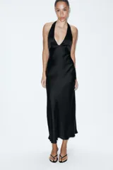 Vestido midi de satén color negro con cuello halter, escote en pico y espalda descubierta con cierre de lazada.
