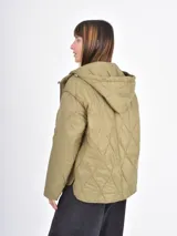 Campera acolchada de color azul, con diseño de costuras en rombos, cierre frontal, capucha y bolsillos delanteros amplios.