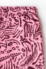 Short de baño rosado con estampado tropical en tono bordó, elástico revestido y cordón ajustable en la cintura, bolsillos laterales y suspensor interior de malla.