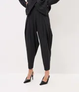 Pantalón de sastre de corte wide leg con diseño de rayas verticales, confeccionado en crepé color gris oscuro. Cuenta con tiro alto, pinzas profundas en el frente y detalle de tira ajustable con botón en el ruedo.