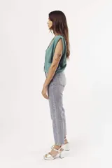 Pantalón de jean celeste de corte mom, con tachas plateadas.