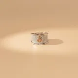 Anillo de banda ancha con textura granulada en plata 925, con un aplique central de una abeja en oro 9k.