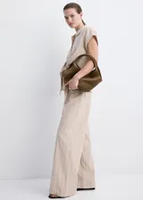 Pantalón recto color beige de tiro medio, con estampado de raya diplomática, trabillas para cinto y cierre frontal con gancho y cremallera.