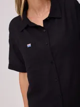 Camisa color verde lima, de manga corta, con bolsillo en el pecho y cierre con botones.