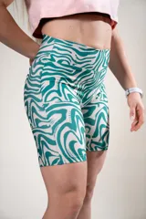 Calza biker deportiva con estampado abstracto en tonos verde y blanco.